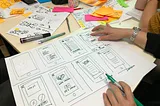 A designer drawing hand-drawn wireframes.