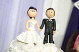 IMAGE: A wedding cake topper with the typical bride and groom figurines