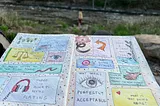 A notebook covered in colorful doodles, background of a river