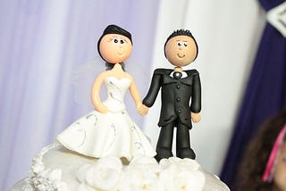 IMAGE: A wedding cake topper with the typical bride and groom figurines