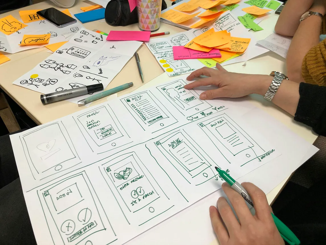 A designer drawing hand-drawn wireframes.