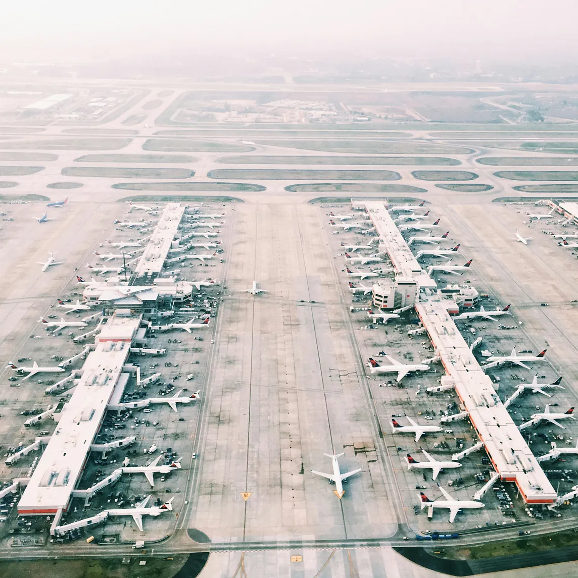 Aerial view of airport with lots of airplanes during daytime