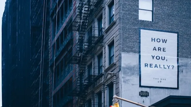 ‘How are you, really?’ poster on a side of a building. Photo by Des Récits on Unsplash