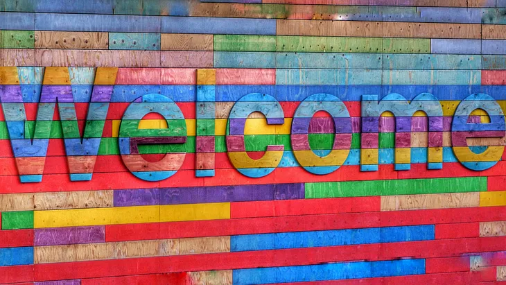 A sign reading welcome made of multi-coloured wood planks