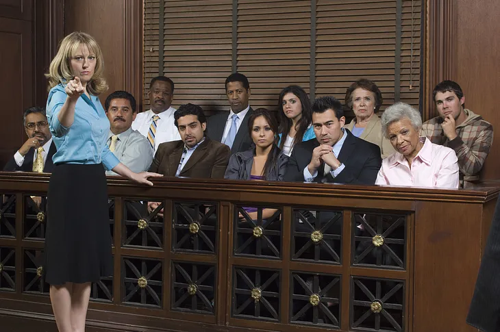 Portrait of a female advocate pointing with jurors sitting together in the witness stand at court house