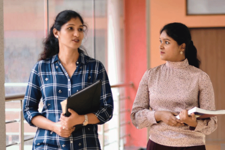 Photo of two students walking and talking