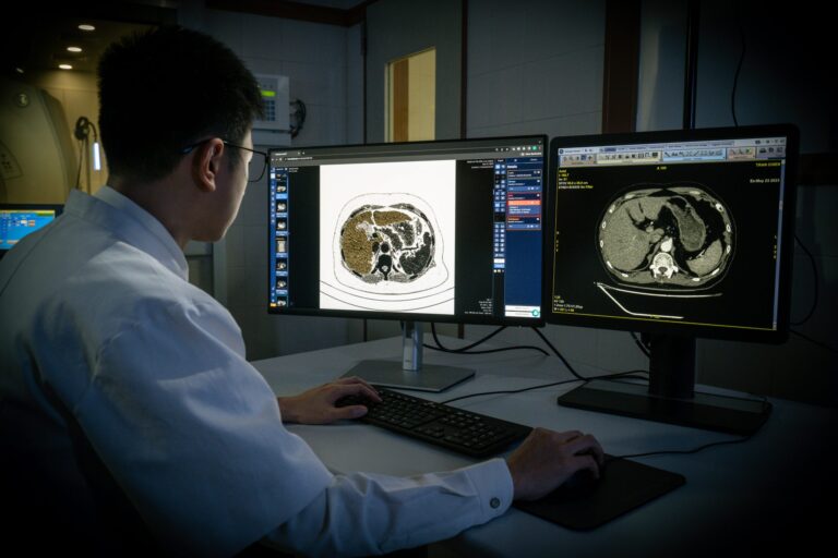 man looking at computer monitors