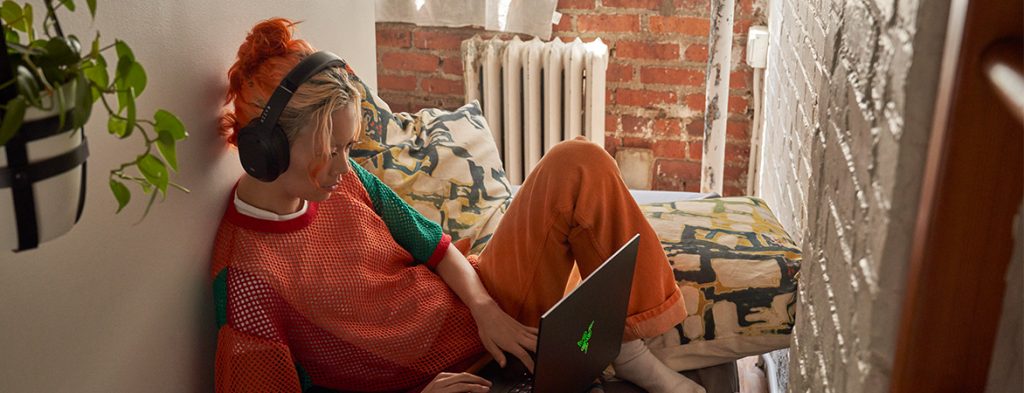 A person sitting on a couch with a computer