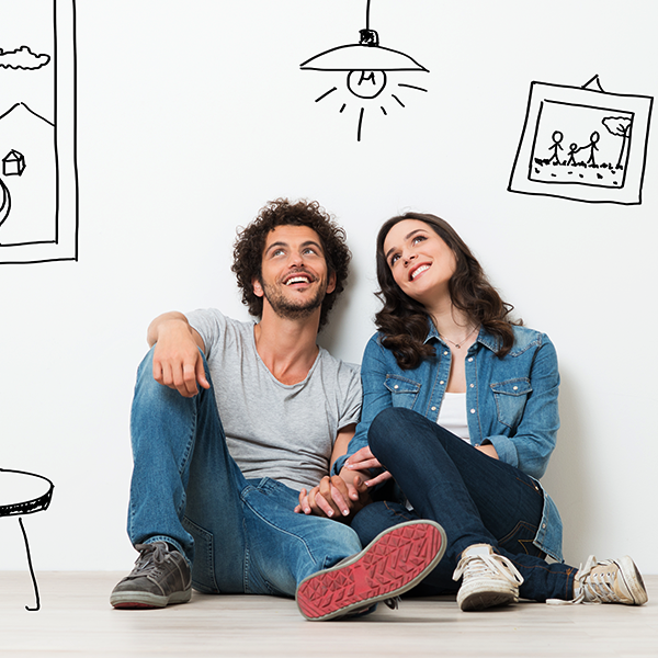 Smiling young couple sitting on the floor looking up thinking of their new home