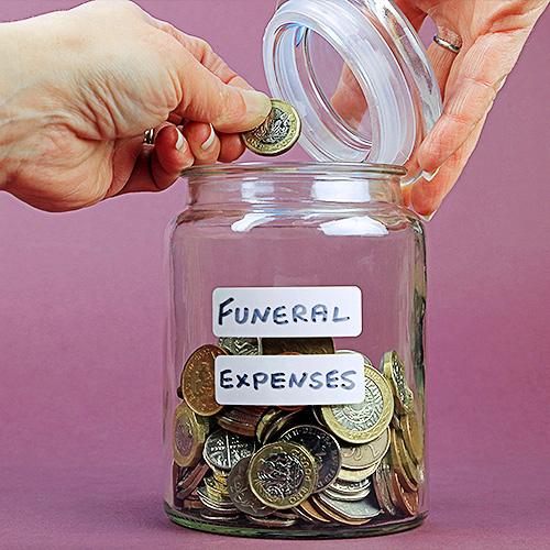 Hand putting coins in glass jar for funeral expenses