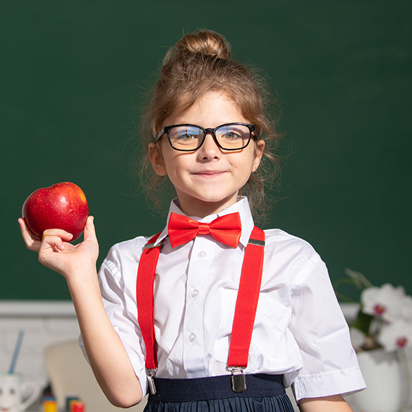 Cute child at school. Kid is learning in class on background of blackboard. Educational process.