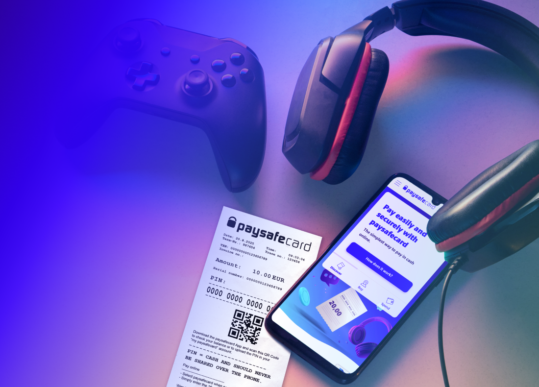 a computer mouse, a controller, a pair of headphones, paysafecard voucher and a smartphone displaying paysafecard website