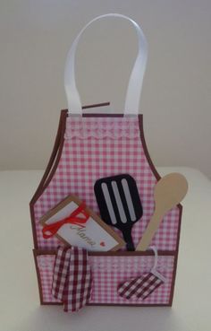 a pink and white checkered paper bag with utensils in it, sitting on a table