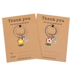 two thank you key chains with flowers on them