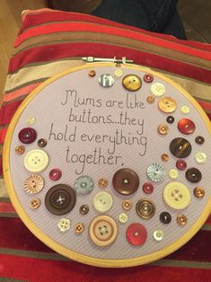 there is a hand embroidered sign with buttons on it that says mums are like buttons they hold everything together