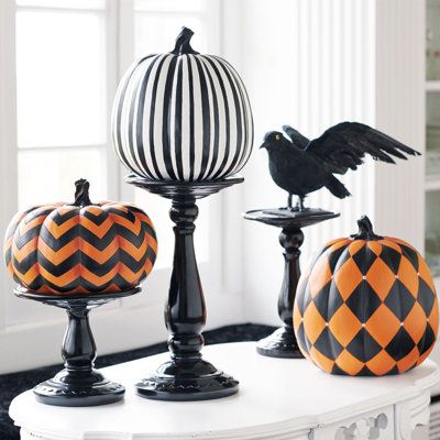 Spray paint dollar store glass candle sticks black and add pumpkins for Halloween decoration