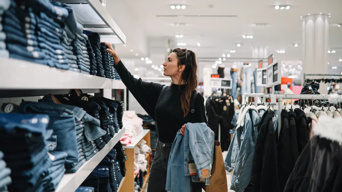 Woman shopping denim jeans in a clothing store