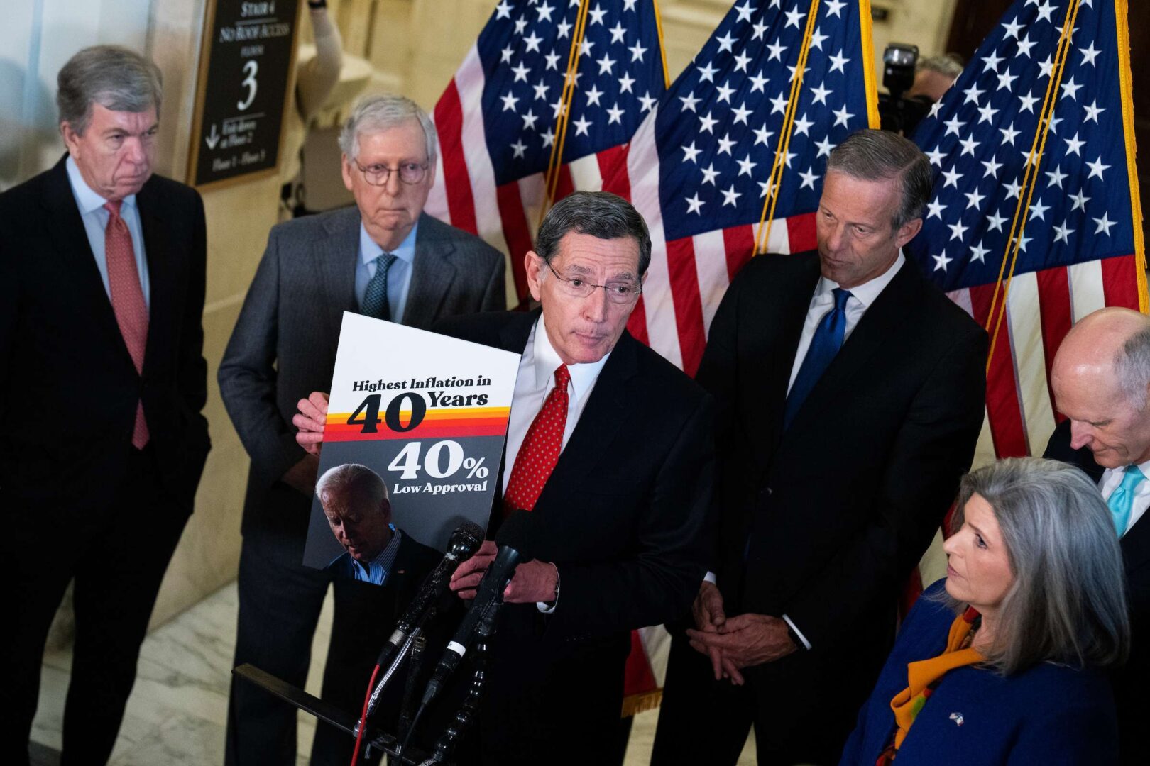 Sen. John Barrasso, R-Wyo., holds a sign about  high inflation after the Republican Senate luncheon in the Russell Senate Office Building on Tuesday. Joining him, clockwise from left, were Sen. Roy Blunt, Senate Minority Leader Mitch McConnell and Sens. John Thune, Rick Scott and Joni Ernst.