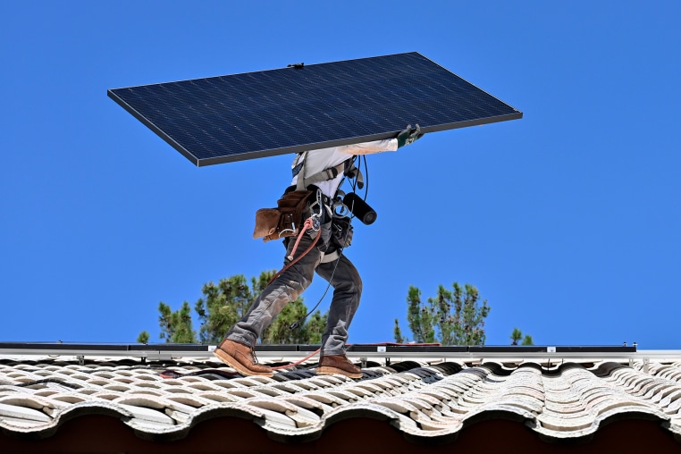 A workers on the roof of a house