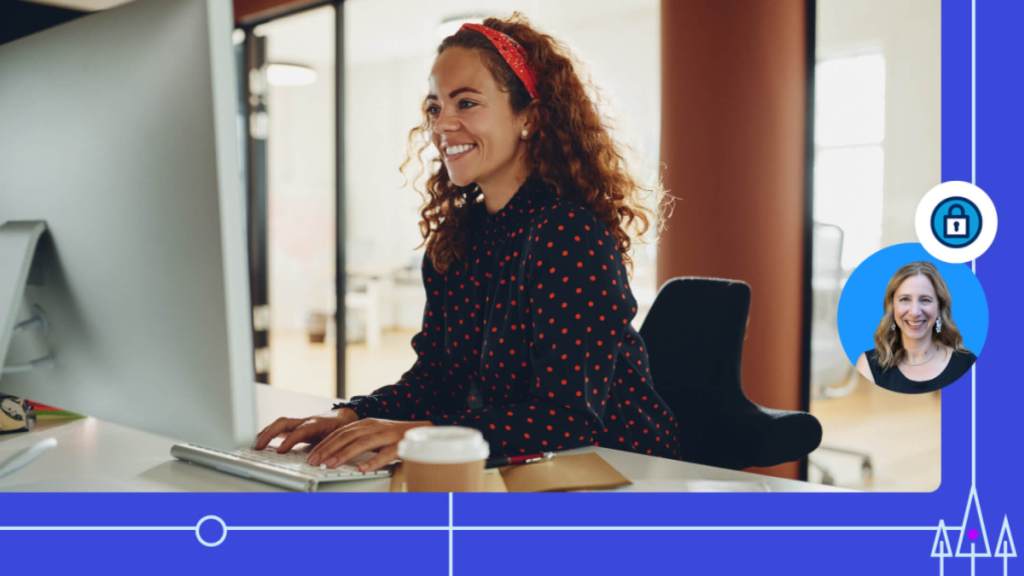 A woman working at a keyboard smiling.	