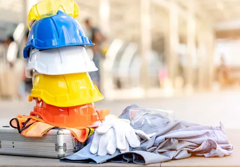 white, yellow and blue hard safety helmet hat and equipment for safety project of workman as engineer or worker, on concrete floor on construction site. Industrial Safety and Construction Standards