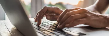 Person working on laptop closeup.