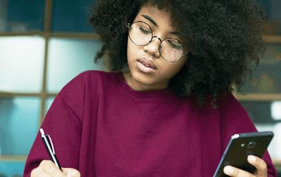 Woman studying while holding a phone