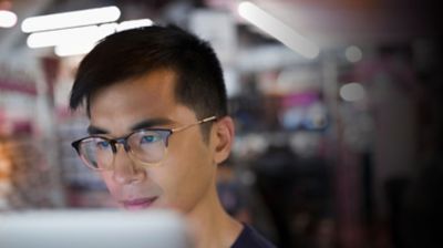 Man with glasses looking at his computer screen.