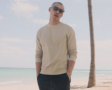 one man on beach in long sleeve tan shirt