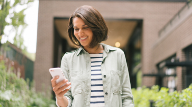 Woman smiling looking at her phone.