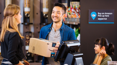 Man and his young child smiling at the store cashier retrieving their package at counter.