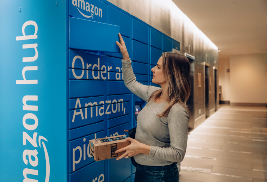 Woman opening a blue Amazon Hub Locker retreiving package.