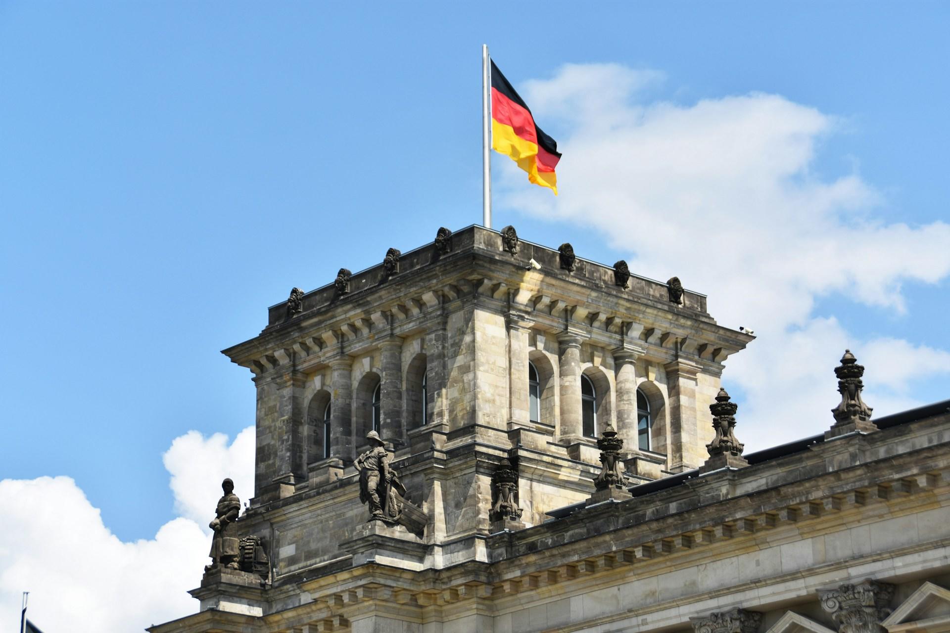 The German flag waving atop a building