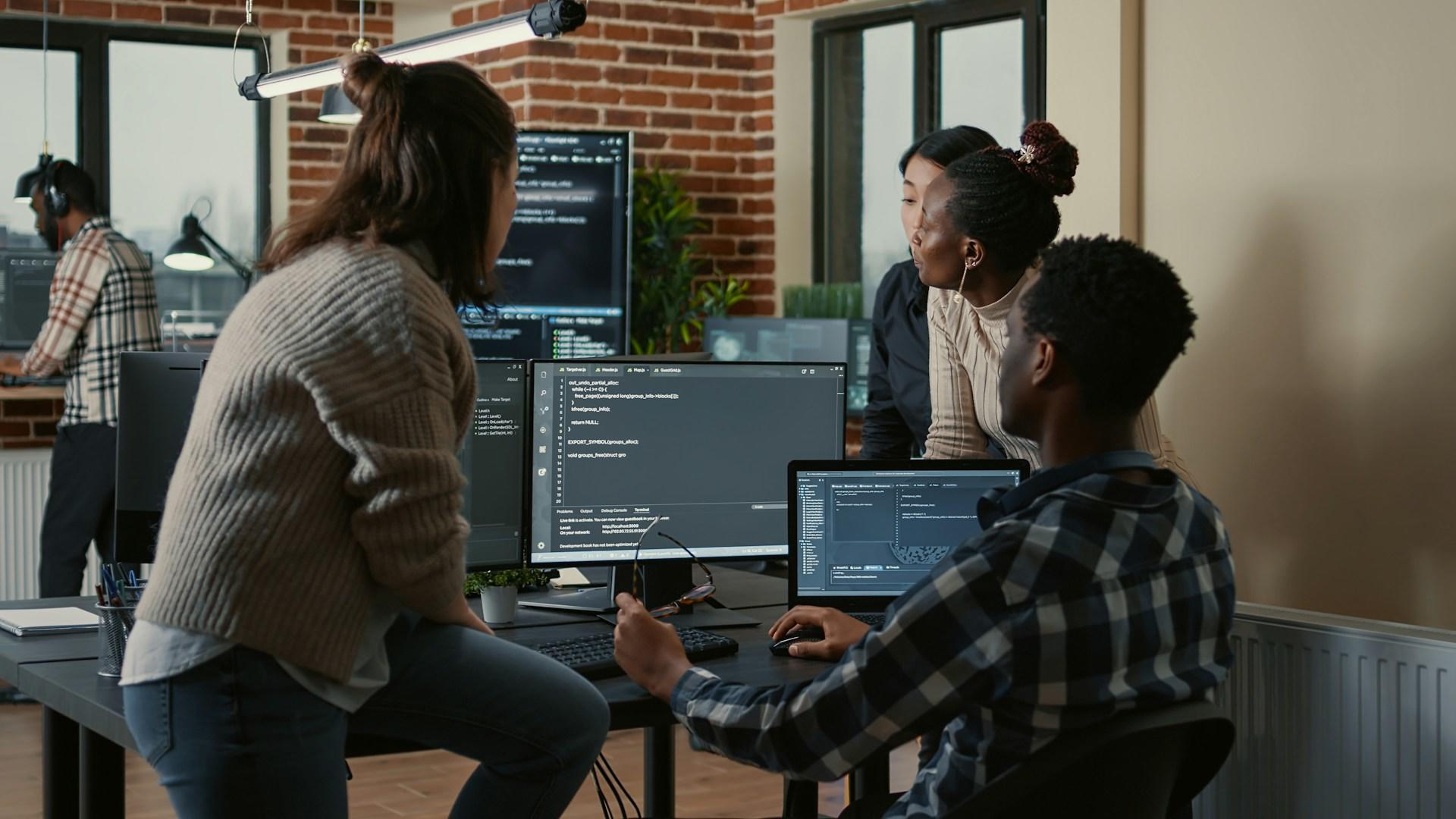 Three colleagues working on computers in an office.