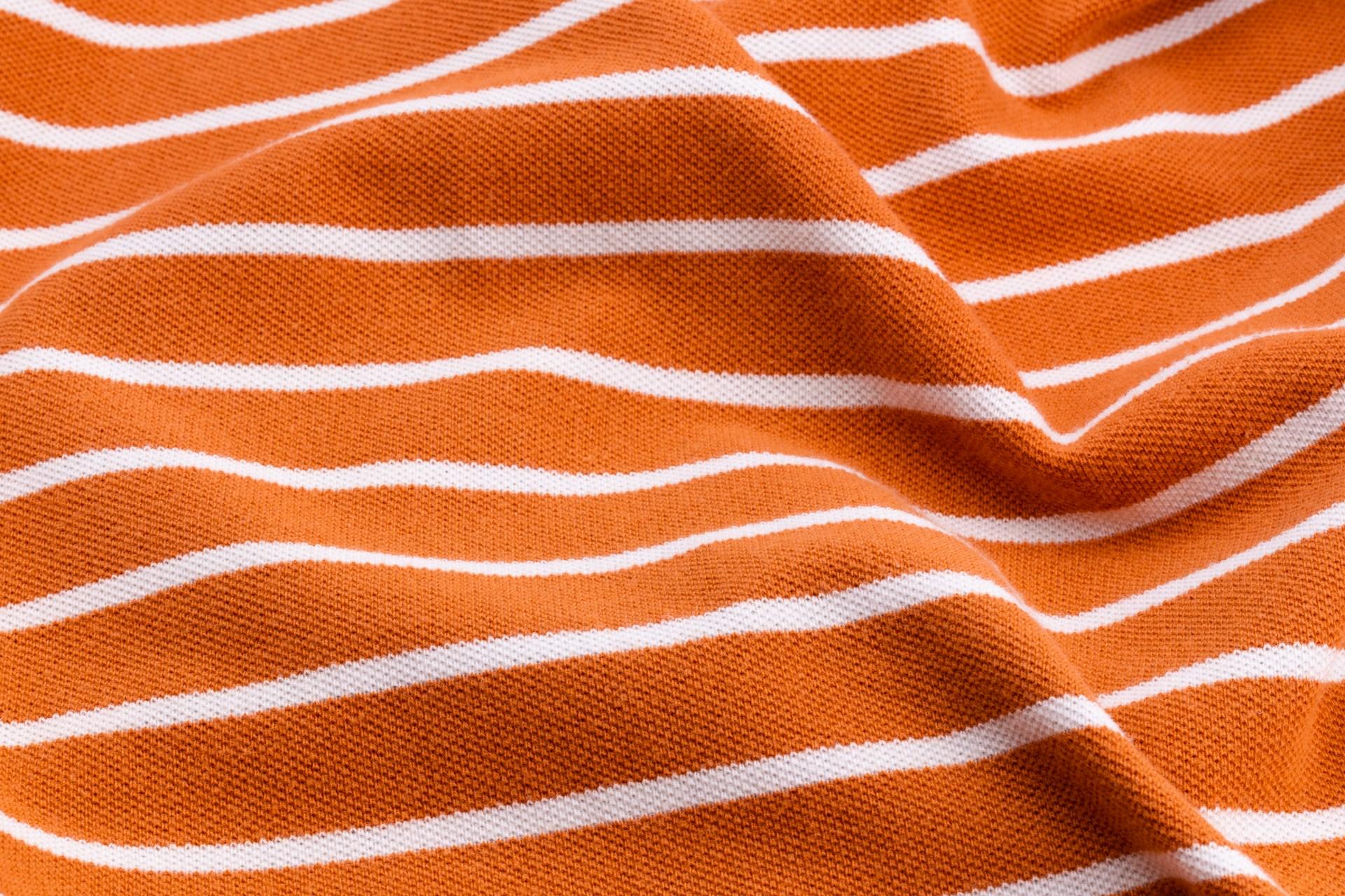 An orange fabric with white stripes.