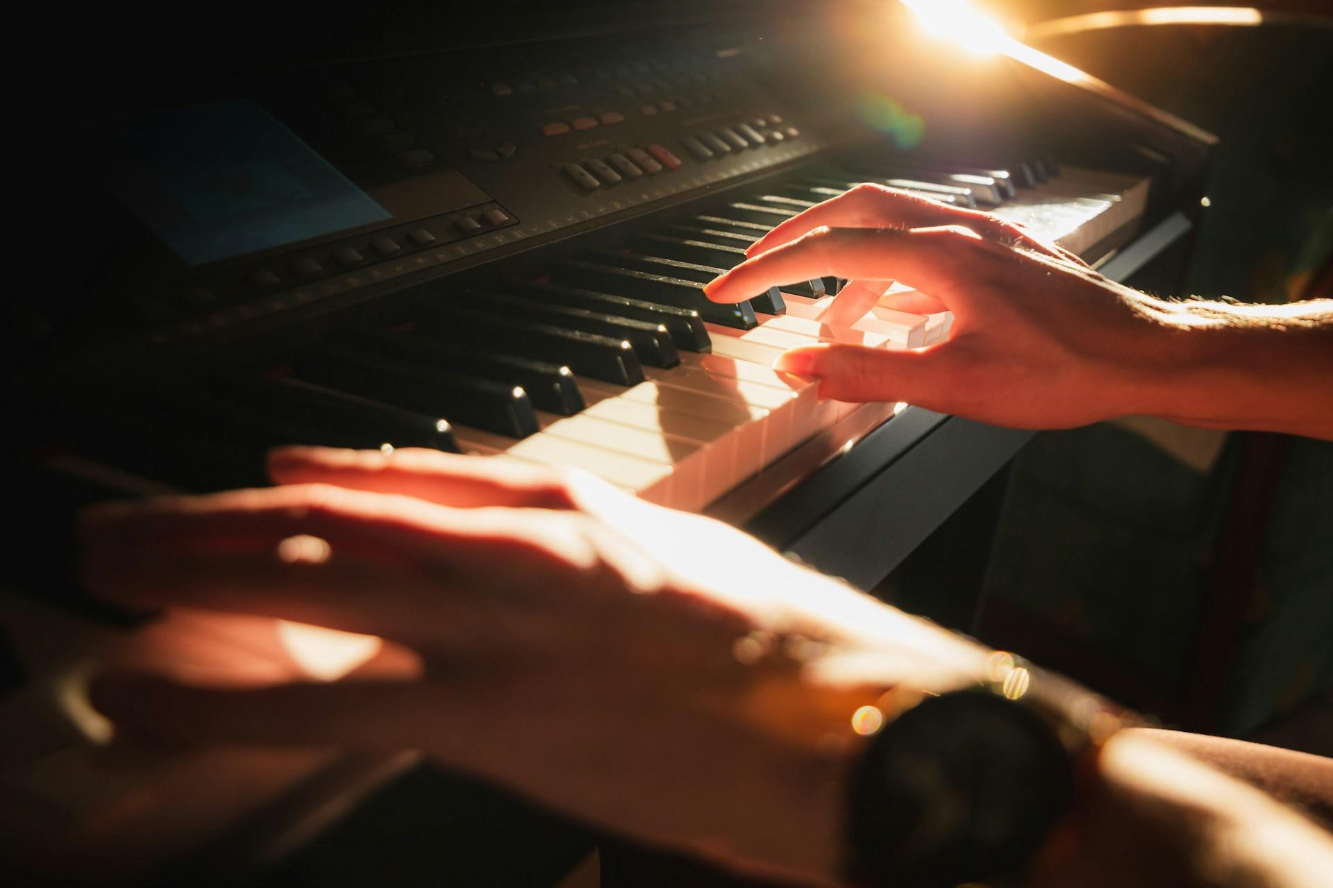 Una persona tocando piano en la oscuridad