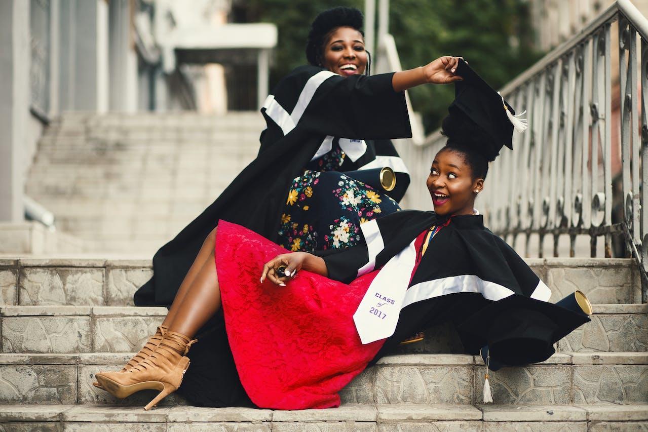 Deux jeunes femmes posent pour la photo de fin de diplôme.