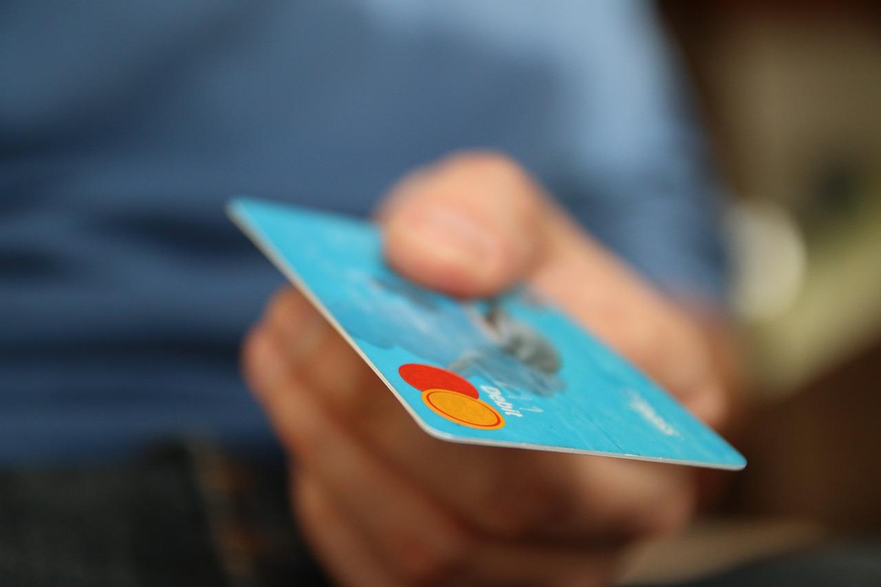 A picture of a person holding a debit card in their hand. Some websites are free and some are paid-for when it comes to learning Dutch online.