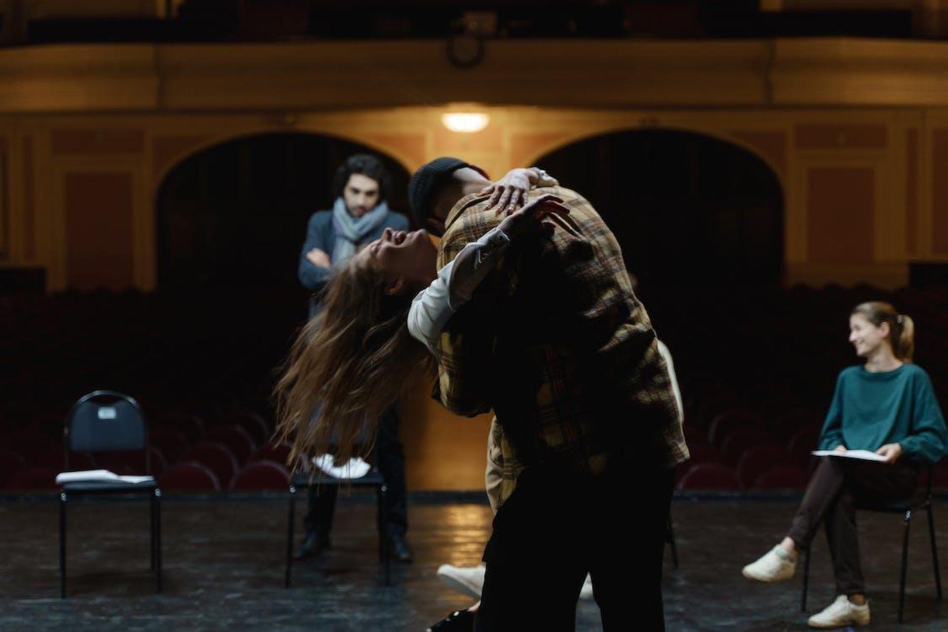 A man hugging a woman on stage.