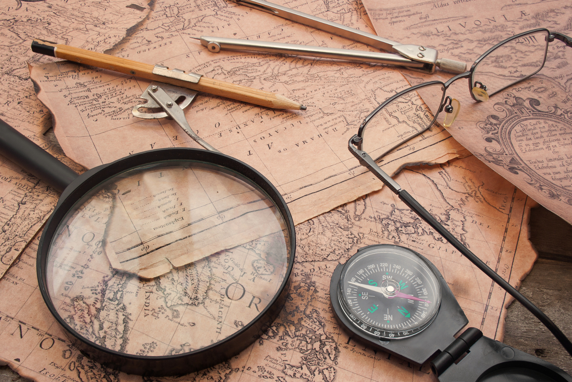 historical map with a magnifying glass and glasses on a table