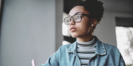 Young woman with glasses and light blue jacket