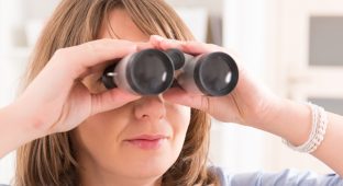 Beautiful woman Looking through binocular at home