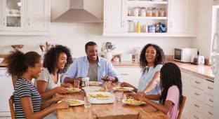 Family With Teenage Children Eating Meal In Kitchen