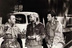 Montgomery Clift, Marlon Brando, and Dean Martin talk during a break in filming The Young Lions.