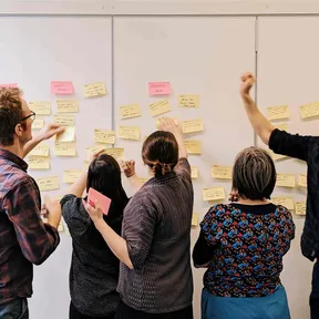 Torchbox team add sticky notes to board during workshop