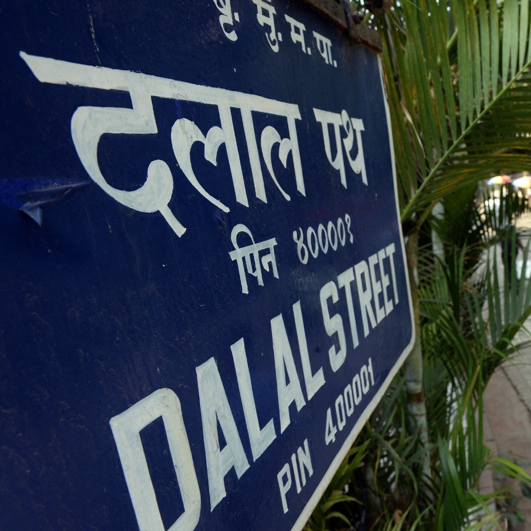 Man walks past Dalal Street logo