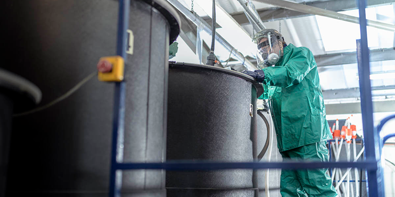 Scientist reviewing a mixing tank in a chemical facility