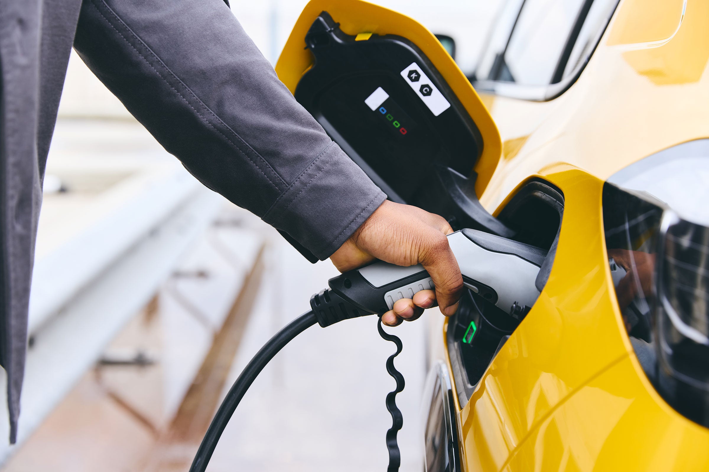 Person plugging their electric vehicle into a charger