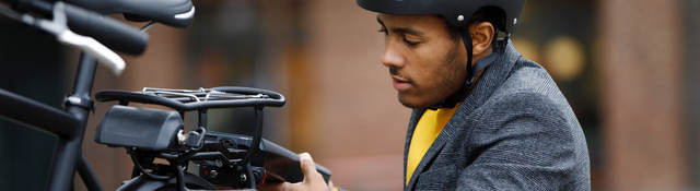 Young man changing battery pack on electric bicycle