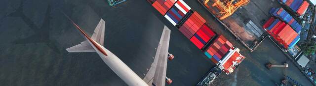 Plane flying over a shipyard